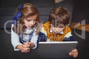 Enjoying activities that can be done anywhere, any time. a little boy and girl using a digital tablet at home.