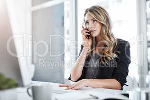 Have you seen the latest business headline. a young businesswoman using a mobile phone and computer at her desk in a modern office.