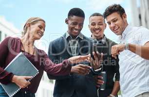 Young, diverse and creative design team and their manager looking at phone together outside from below. Female leader, boss or CEO showing new staff or interns the company website during orientation