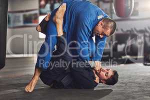 Most fights end up on the ground. Full length shot of two professional fighters sparring in the gym.