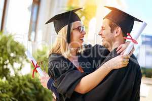 Our relationship can survive anything after this. a young couple embracing each other on graduation day.