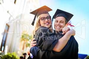 Were feeling all the feels right now. a young couple embracing each other on graduation day.