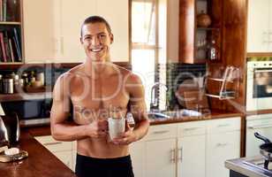 To cheer up he has a cup of coffee. handsome young shirtless man drinking a cup of coffee in the kitchen at home.