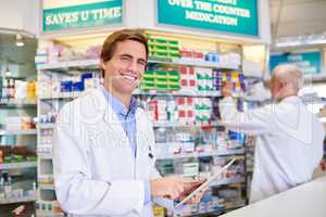 Wireless technology makes our day-to-day running so much easier. Portrait of a young pharmacist using a digital tablet while in a chemist.