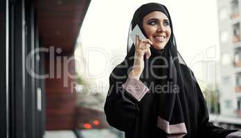 Sounds good to me. an attractive young businesswoman dressed in Islamic traditional clothing making a phonecall while standing on her office balcony.