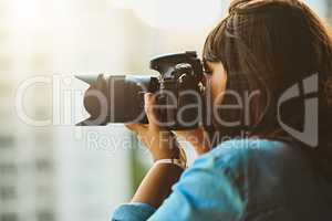 Seeing and capturing the world. a woman taking pictures with her camera outside.