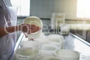 Handmade cheese. an unrecognizable female farm worker making cheese in a factory on the farm.