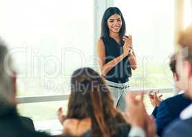Giving her a round of applause. an attractive young businesswoman fielding questions from her colleagues during a seminar.