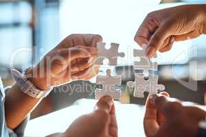 We all form a piece of the bigger picture. Closeup shot of an unrecognizable group of people joining puzzle pieces together.