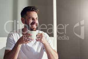 Theres so much to love about a fresh cuppa coffee. a handsome young man drinking coffee in the bedroom at home.