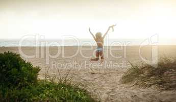 Life is a gift, live it. Rearview shot of a happy young woman enjoying a day at the beach.