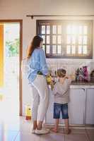 Teach them skills that will benefit them for life. Rearview shot of a mother and her little son washing dishes together at home.