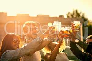 Its better having great friends instead of a ton. a group of young friends having a drink and spending the day outside on a rooftop.