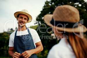 Ask away. a handsome man talking to his young daughter while working on their farm.