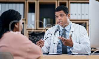 Doctor talking to patient in medical consultation, checkup and visit in clinic, hospital and healthcare center. Professional, gp and frontline worker explaining symptoms while asking woman questions