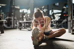 Stretch beyond your limits. a young woman doing stretch exercises at the gym.