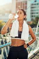 You cant do your best if youre not properly hydrated. a sporty young woman taking a break while exercising in the city.