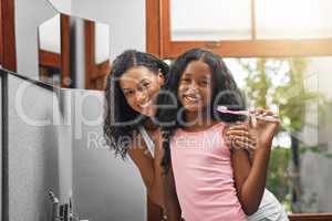 We take pride in our oral hygiene. Cropped portrait of an attractive young woman and her daughter brushing their teeth in the bathroom at home.
