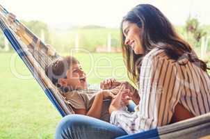 Spending some alone time with her son. an attractive young woman and her son bonding outside on the hammock.