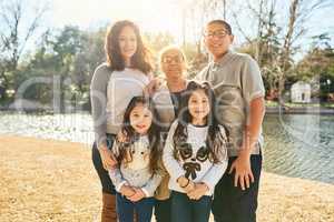 Happiness is right here, right now with family. Portrait of a happy multigenerational family spending time together outdoors.