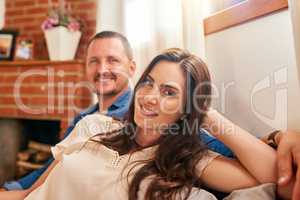 Our quality time is a relaxing time. Portrait of a happy young couple relaxing together on the sofa at home.