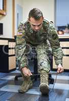 Battle is better in boots. a young soldier tying his boot shoelaces in the dorms of a military academy.