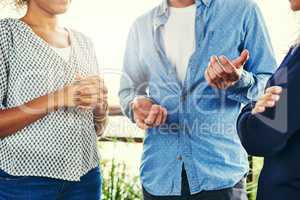 In discussion about continuing their team success. Closeup shot of a group of unrecognizable businesspeople having a discussion outdoors.