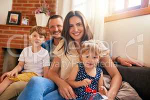 Nothing can replace family time. Portrait of a happy young family of four relaxing together on the sofa at home.