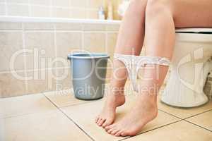 Flush with a bucket of water to save water. an unrecognizable woman using the toilet at home.