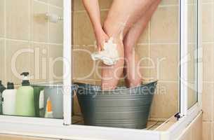 There are simple ways to save water. an unrecognizable woman washing in a bucket that has been placed in the shower at home.