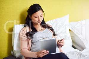 Shopping for new maternity wear. a pregnant woman using a digital tablet and credit card at home.