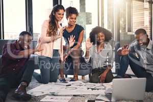 Connected across the globe. a group of young entrepreneurs going through paperwork together in a modern office.