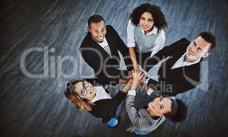 Its better to work as a collective. High angle shot of a group of businesspeople joining their hands together in a huddle.