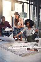 Openness and transparency are the hallmarks of success. a group of young entrepreneurs going through paperwork together in a modern office.