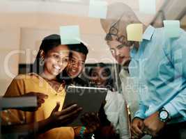 Group of creative, excited and smiling design team, working, researching and browsing on tablet for innovation ideas in modern office. Office workers planning a group work project after hours.