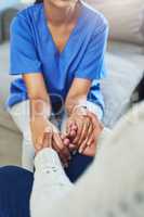 Ill be there whenever you need support. an unrecognizable female nurse holding a patients hands in support while being seated on a couch at home during the day.