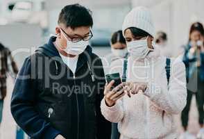 People in covid face mask and phone searching information online looking at the news on travel ban restriction on social media while stranded at the border. Modern foreign traveling people at airport