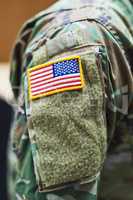 Ready to fight the good fight. a soldier wearing camouflage fatigues with an american flag for a patch.