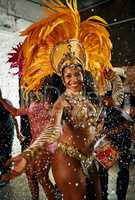 Find your rhythm. Cropped portrait of a beautiful samba dancer performing in a carnival with her band.