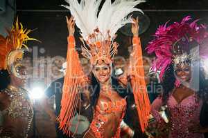 Well take you on a musical adventure. three beautiful samba dancers performing in a carnival with their band.