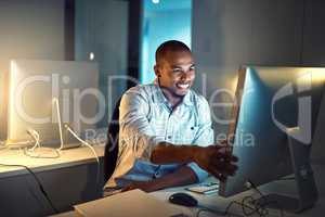Getting it all done before the deadline. a young businessman working late in an office.