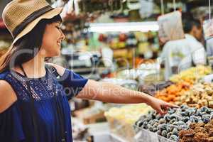 Id like one of those thank you. a cheerful young woman browsing through a market deciding what to buy outside during the day.