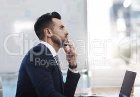 Eyes set firmly on the prize. a young businessman looking thoughtful in an office.