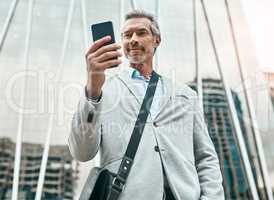 His connections across the city continue to increase. a mature businessman using a cellphone in the city.