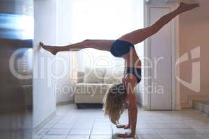 Stretch your limits. Full length shot of an attractive young female athlete working out at home.