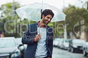 Nothing can put on damper on his good mood. a handsome young businessman on his morning commute in the rain.