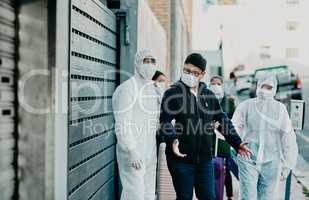 Man breaking covid regulation getting taken away or arrested by healthcare workers wearing hazmat protective suits. Male removed for not following the rules or restrictions of coronavirus pandemic