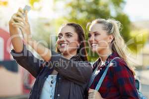 We take photos to look back at our experiences. two beautiful female friends taking a selfie in the city.