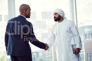 Work with the best, be the best. two businessmen shaking hands in a modern office.