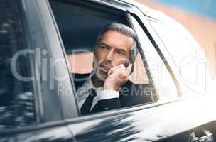 Im pulling up to your building right now. a handsome mature businessman making a call from the backseat of a car during his morning commute.